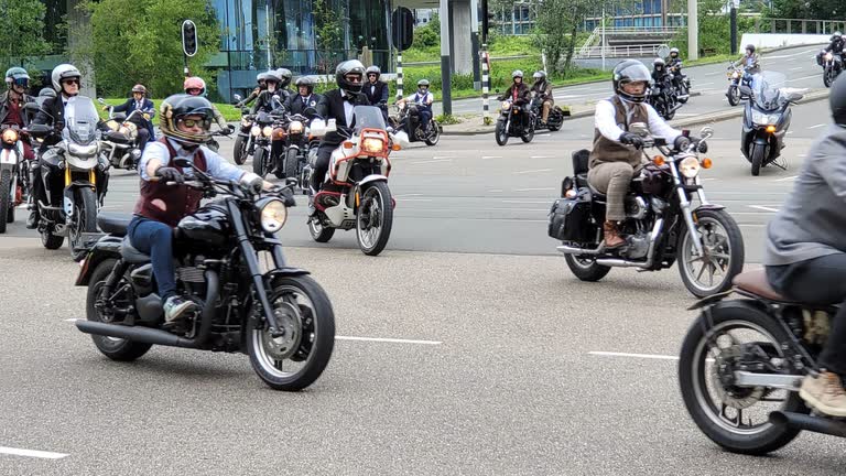 Een stoet stijlvol geklede motorrijders rijdt op klassieke motoren door de stad